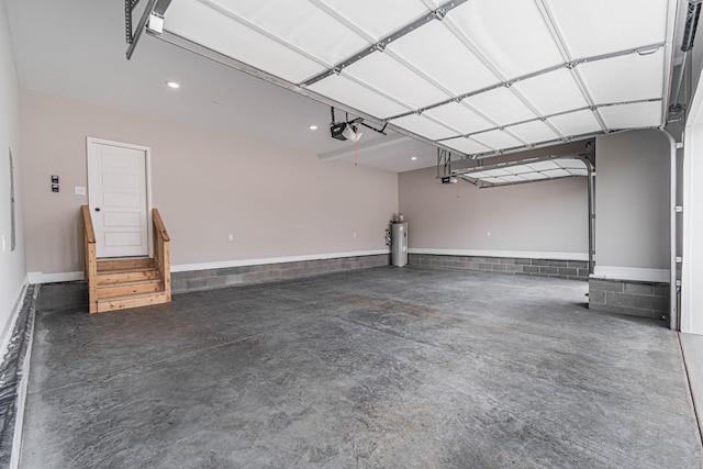 garage with a garage door opener and electric water heater