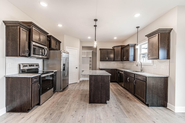 kitchen with light wood-style flooring, appliances with stainless steel finishes, dark brown cabinets, and a sink