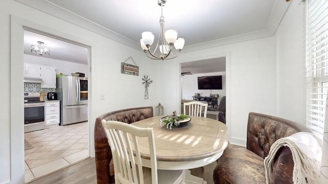 dining room with ornamental molding, light tile patterned flooring, and a notable chandelier