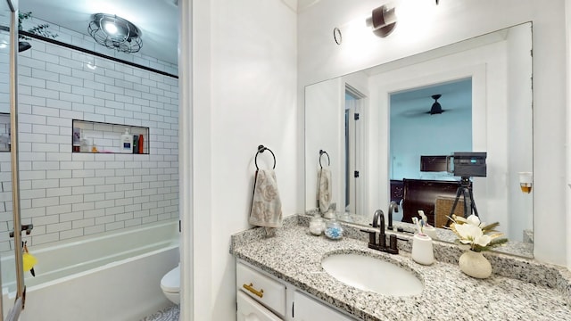 full bath with a ceiling fan, shower / bath combination, vanity, and toilet