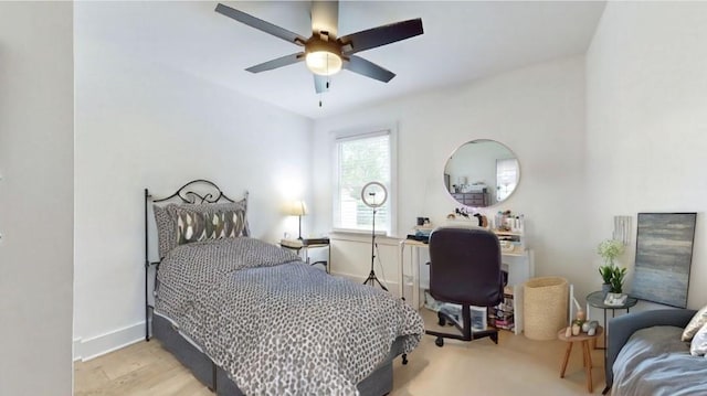 bedroom with wood finished floors, a ceiling fan, and baseboards