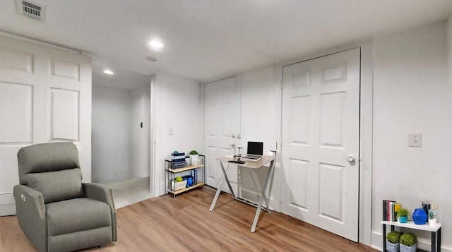 living area with light wood-style floors, recessed lighting, and visible vents