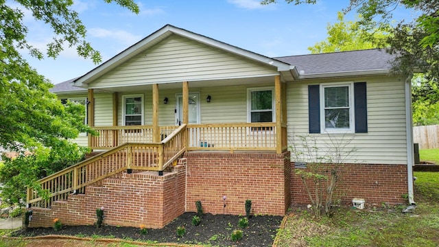 view of front of house featuring a porch, roof with shingles, and stairs