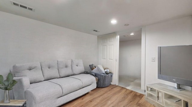 living room featuring light wood-type flooring, visible vents, and recessed lighting