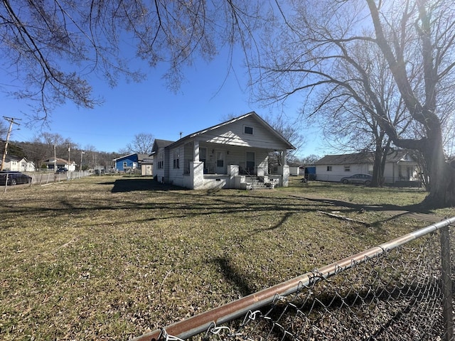 rear view of property with fence, a porch, and a lawn