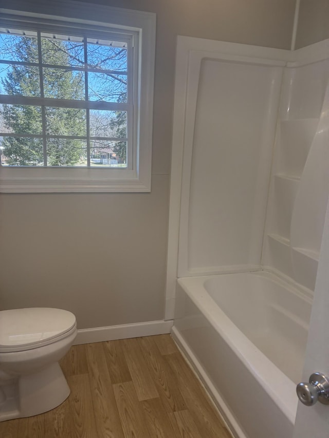 bathroom with baseboards, toilet, and wood finished floors