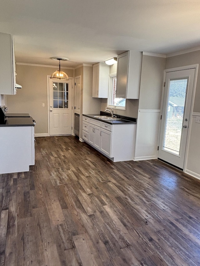 kitchen featuring dark wood-style flooring, a sink, white cabinets, dark countertops, and crown molding