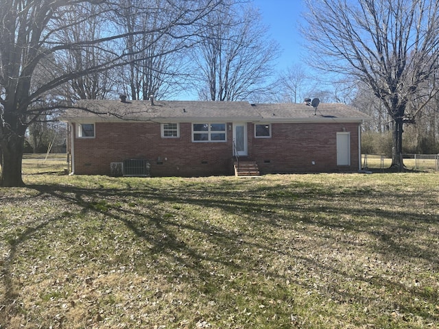 rear view of house with entry steps, brick siding, crawl space, and fence