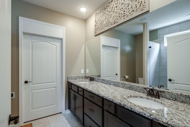 full bathroom featuring toilet, visible vents, a tile shower, and a sink