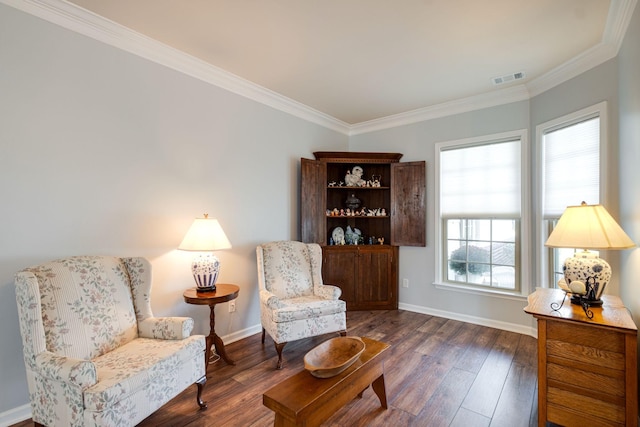 sitting room with baseboards, crown molding, visible vents, and wood finished floors