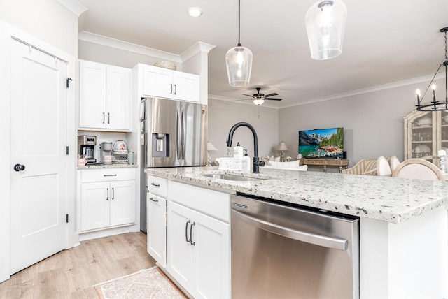 kitchen with a sink, ornamental molding, appliances with stainless steel finishes, and a ceiling fan