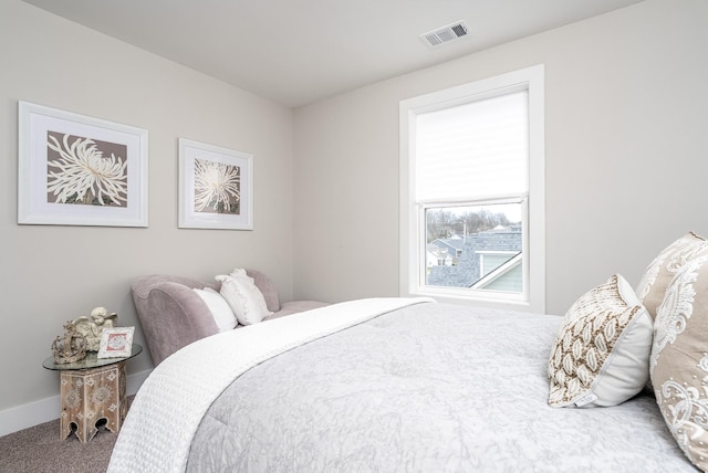 carpeted bedroom featuring baseboards and visible vents