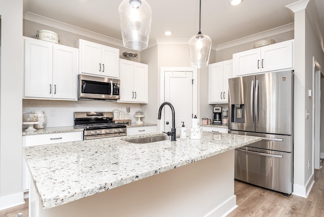 kitchen with ornamental molding, a sink, white cabinets, and appliances with stainless steel finishes