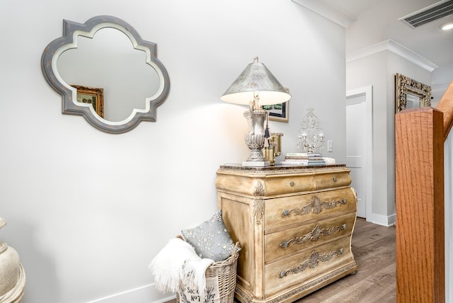 details featuring baseboards, visible vents, wood finished floors, and ornamental molding