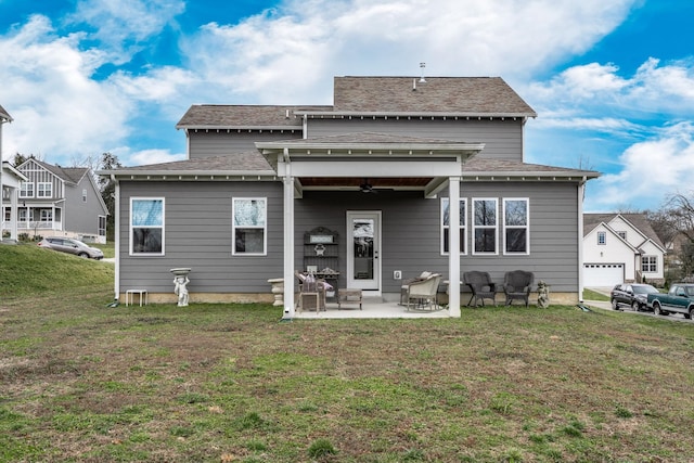 rear view of property with roof with shingles, a lawn, ceiling fan, and a patio