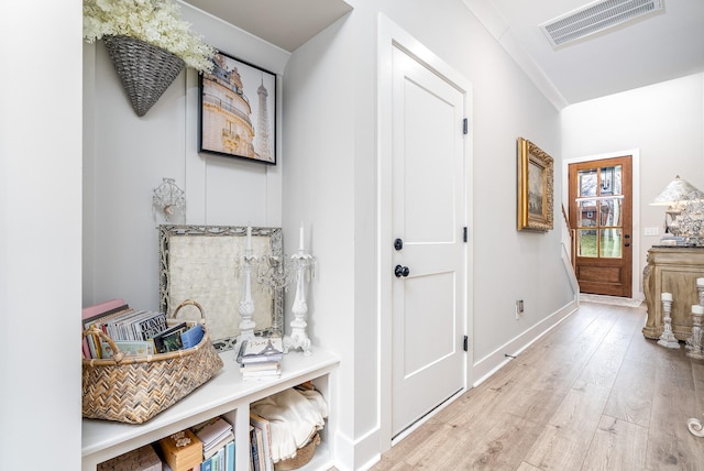 corridor with hardwood / wood-style floors, baseboards, and visible vents