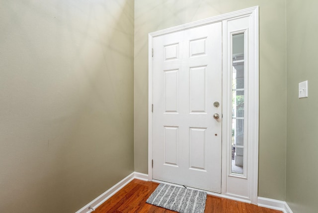 entryway with dark wood-type flooring and baseboards