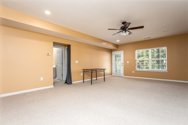 spare room with recessed lighting, light colored carpet, a ceiling fan, visible vents, and baseboards