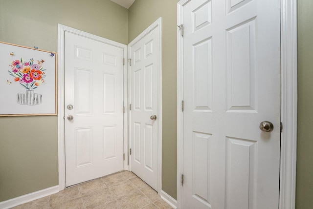 doorway to outside featuring baseboards and light tile patterned floors