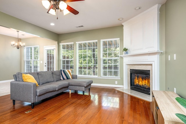 living room featuring visible vents, hardwood / wood-style floors, a high end fireplace, and a wealth of natural light