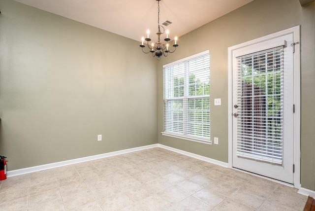 unfurnished room featuring an inviting chandelier, visible vents, and baseboards