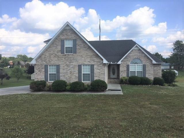 view of front of house featuring a front lawn and brick siding