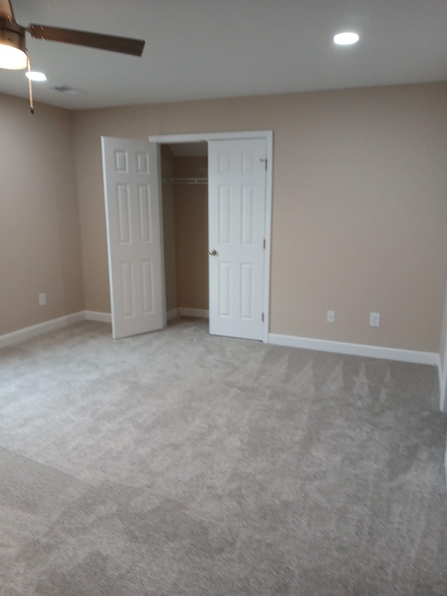 unfurnished bedroom featuring carpet floors, a ceiling fan, baseboards, and a closet