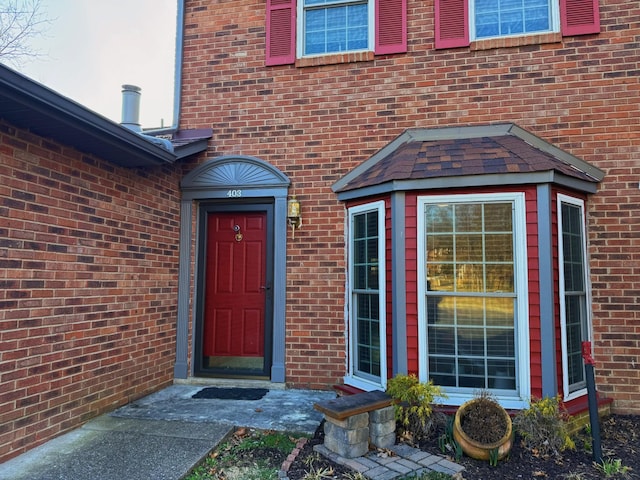 view of exterior entry with brick siding