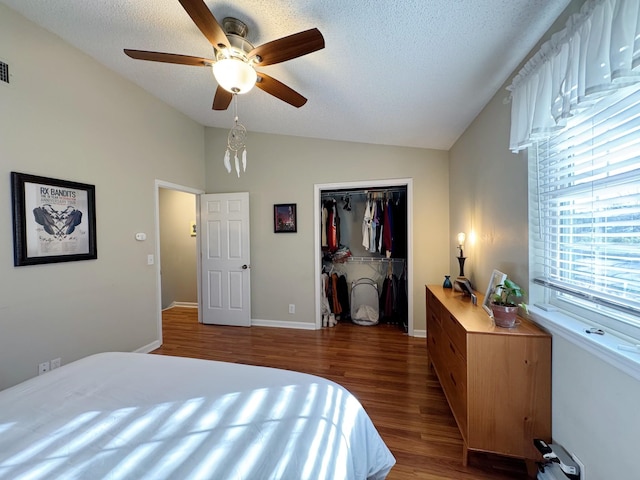 bedroom featuring vaulted ceiling, a closet, wood finished floors, and a textured ceiling