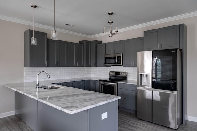 kitchen with a peninsula, a sink, visible vents, appliances with stainless steel finishes, and light stone countertops