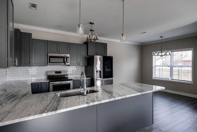 kitchen featuring tasteful backsplash, visible vents, appliances with stainless steel finishes, light stone countertops, and a sink