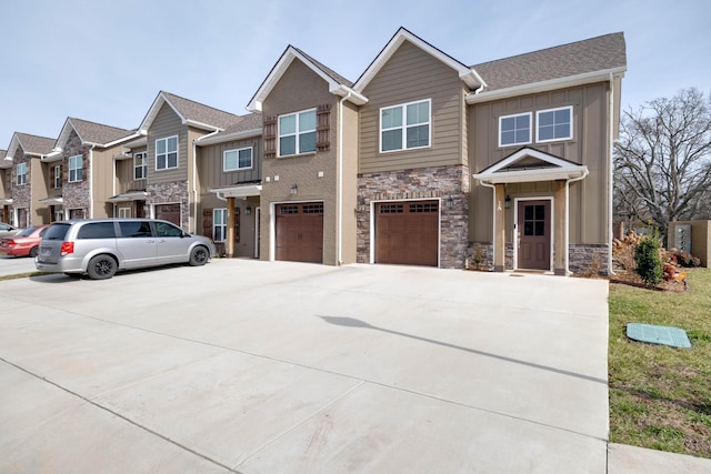 view of front of property with an attached garage, board and batten siding, a residential view, stone siding, and driveway