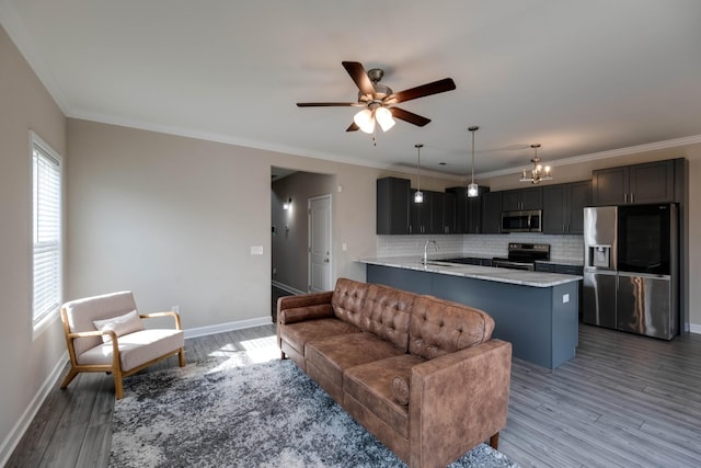 living area featuring ornamental molding, wood finished floors, and baseboards