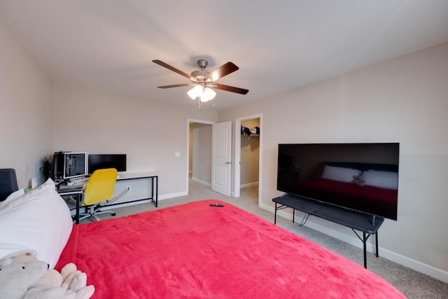 bedroom featuring carpet floors, ceiling fan, baseboards, and a walk in closet