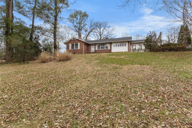 view of front of house with crawl space, brick siding, and a front lawn