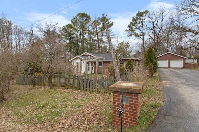 view of yard with a fenced front yard, an outbuilding, and a garage