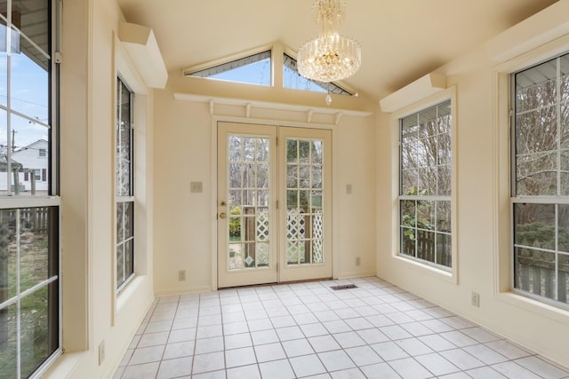 unfurnished sunroom featuring lofted ceiling, visible vents, and a notable chandelier