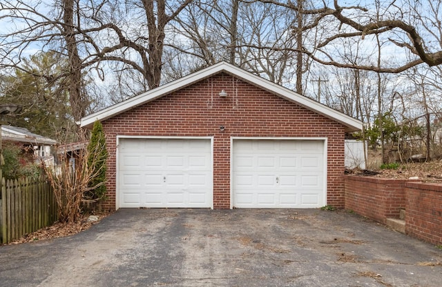 detached garage featuring fence