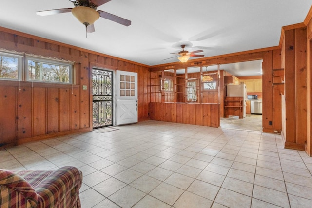 interior space featuring light tile patterned floors, wood walls, and a ceiling fan