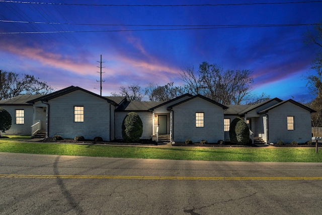 ranch-style house featuring entry steps and a yard