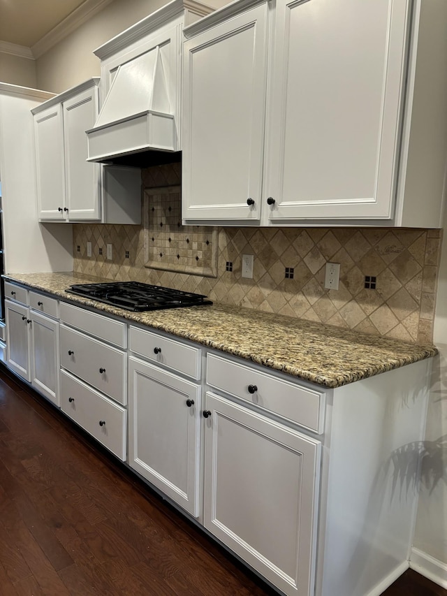 kitchen with black gas cooktop, dark wood-type flooring, white cabinetry, custom exhaust hood, and crown molding