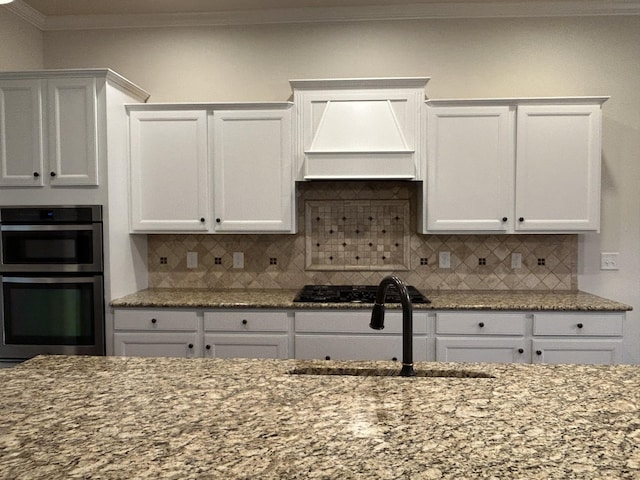 1012 Wooden Gate Dr, Franklin, TN 37064 - kitchen with custom exhaust hood, a sink, black gas stovetop, crown molding, and white cabinetry