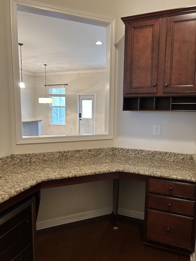 1012 Wooden Gate Dr, Franklin, TN 37064 - kitchen with dark wood-type flooring, dark brown cabinetry, ornamental molding, hanging light fixtures, and light stone counters