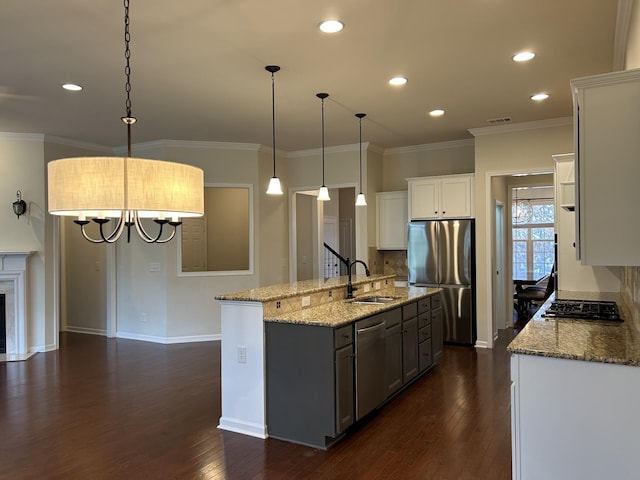 1012 Wooden Gate Dr, Franklin, TN 37064 - kitchen featuring stainless steel appliances, a sink, dark wood-style flooring, light stone counters, and a center island with sink