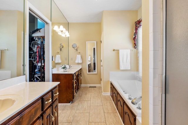 full bathroom with a bath, a sink, baseboards, and two vanities