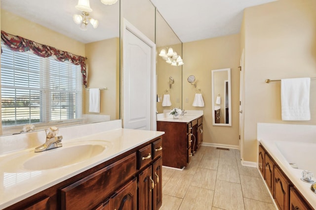 full bath with a garden tub, a sink, visible vents, and an inviting chandelier