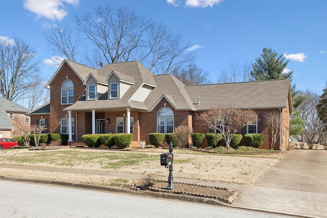 view of front of home with brick siding and a shingled roof