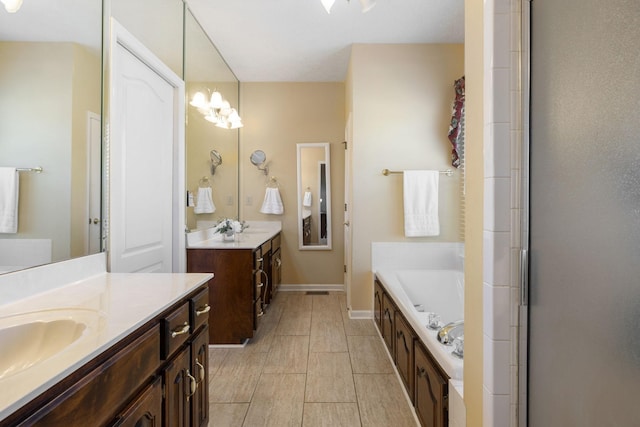 bathroom with a sink, two vanities, a bath, and baseboards