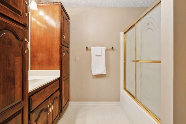 full bathroom with shower / bath combination with glass door, a textured ceiling, vanity, baseboards, and tile patterned floors