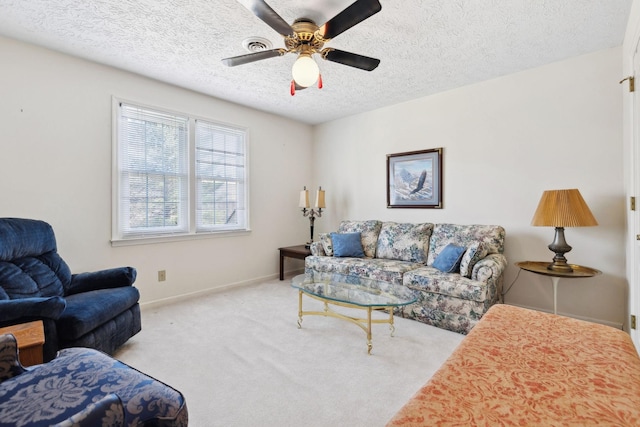 living room featuring carpet floors, ceiling fan, a textured ceiling, and baseboards